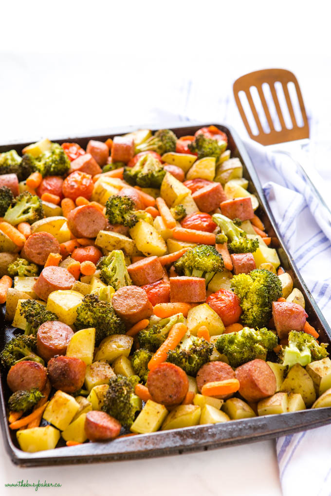 sheet pan dinner with broccoli, potatoes, carrots, and sausages