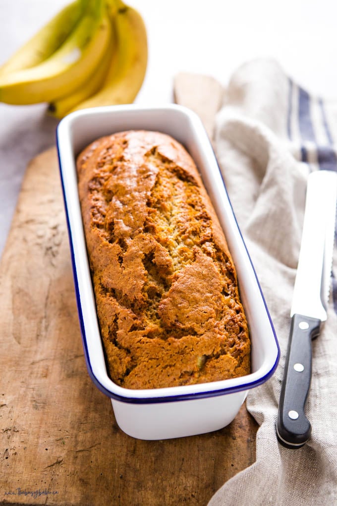 loaf of vegan banana bread in white enamel tin