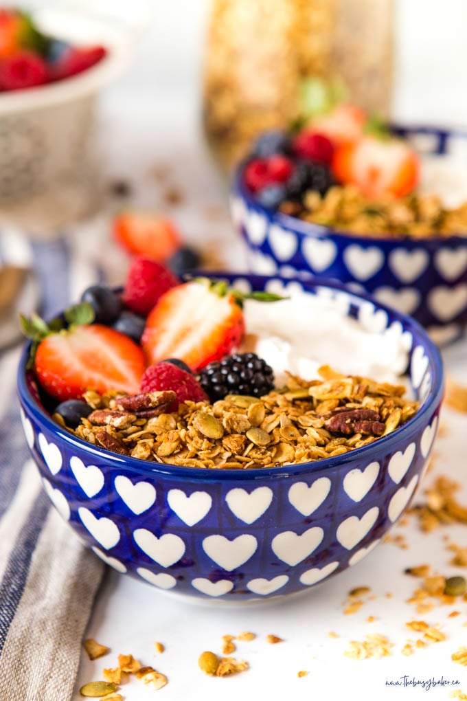 closeup image: homemade granola in bowl with berries and yogurt