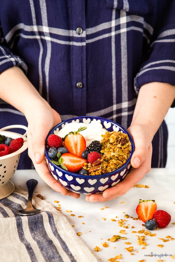 homemade granola in a blue bowl with berries and yogurt