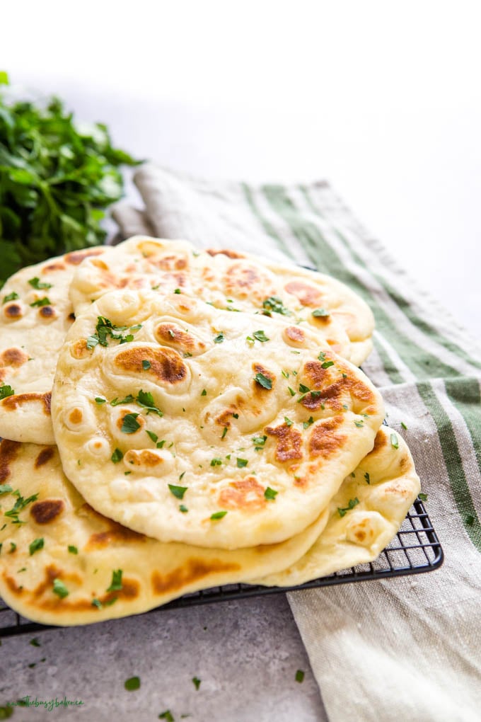 naan bread on cooling rack with green herbs