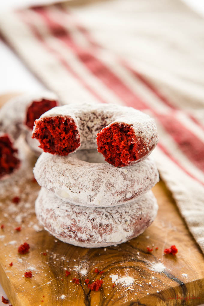 stack of 3 red velvet donuts with powdered sugar