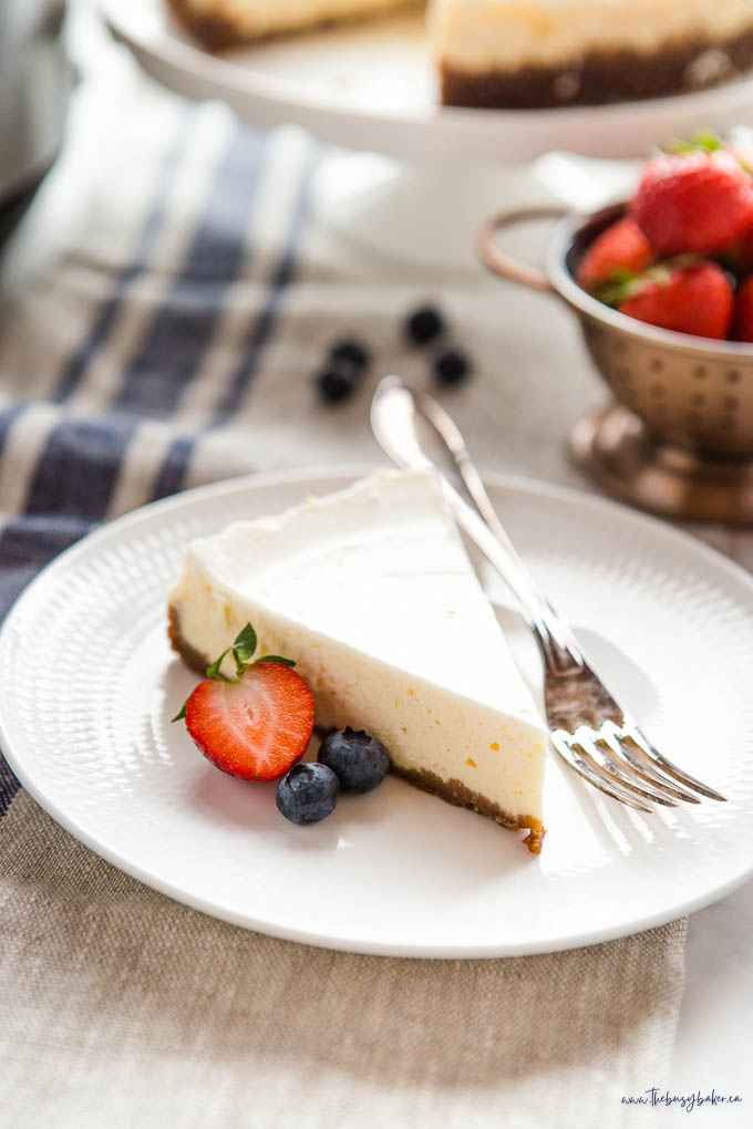 slice of cheesecake on white plate with berries