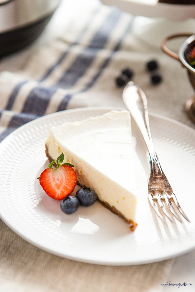 slice of cheesecake on white plate with vintage fork