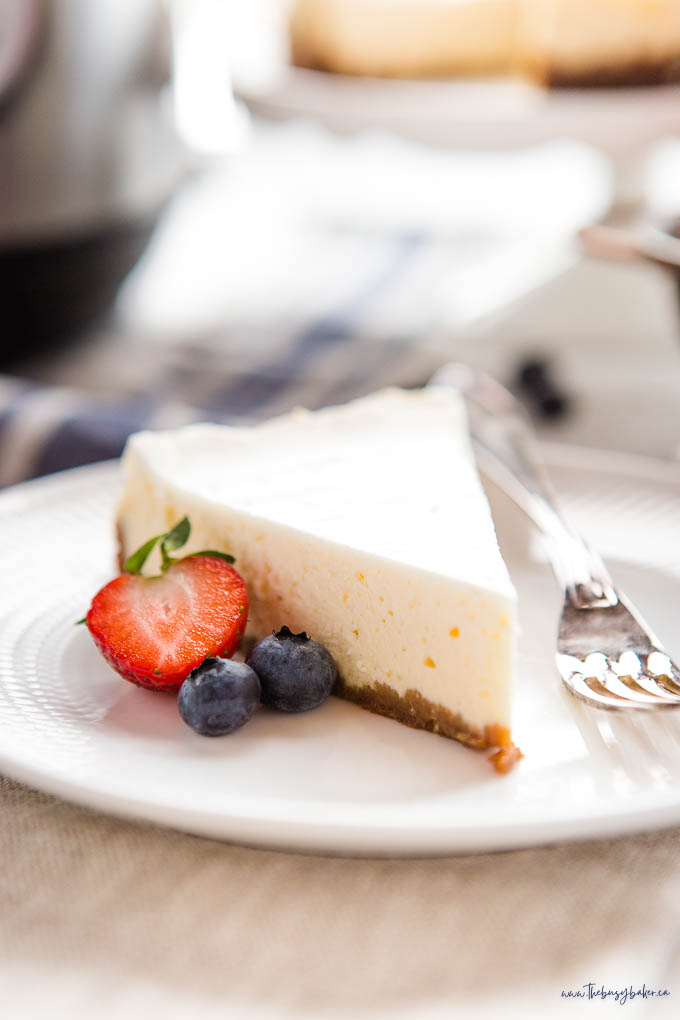 slice of cheesecake on white plate with berries