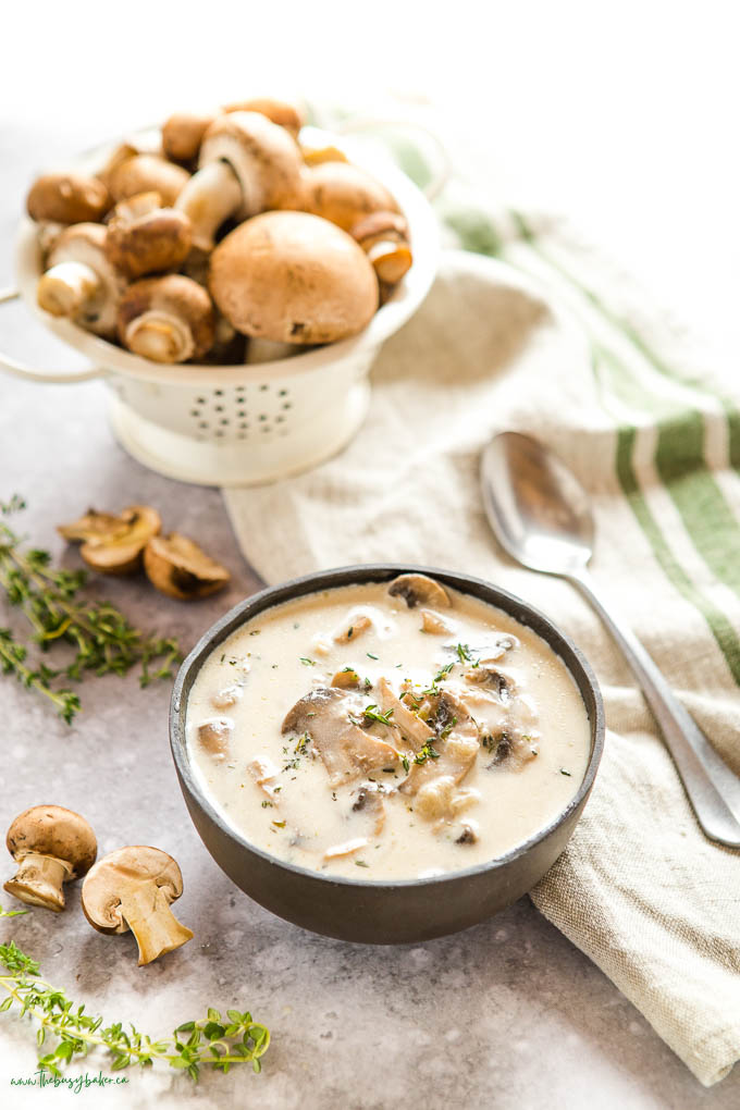 bowl of creamy mushroom soup with fresh mushrooms and thyme