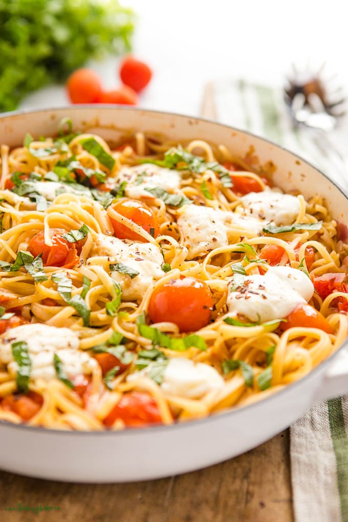 close-up image: one pot pasta made with linguine, tomatoes, mozzarella, and fresh basil