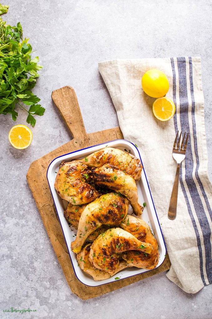 overhead image: grilled chicken legs on white platter