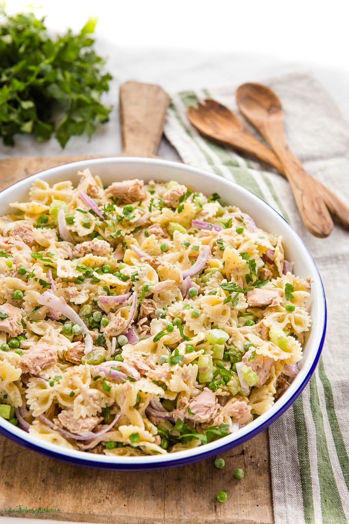 Tuna salad in while bowl on wood cutting board