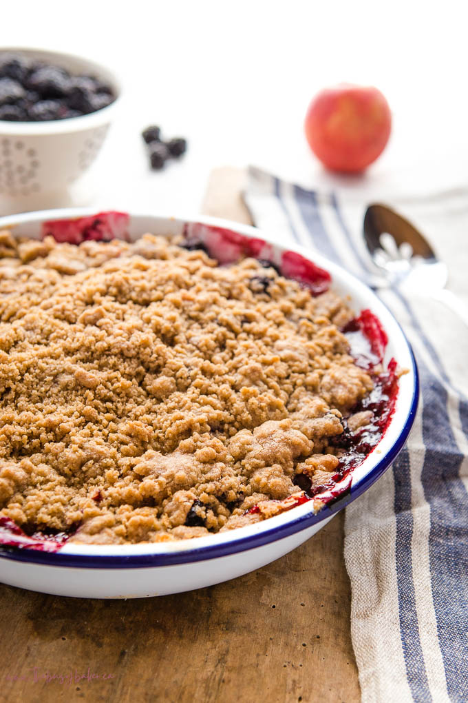 apple and blackberry crumble in white enamel baking dish with blue rim