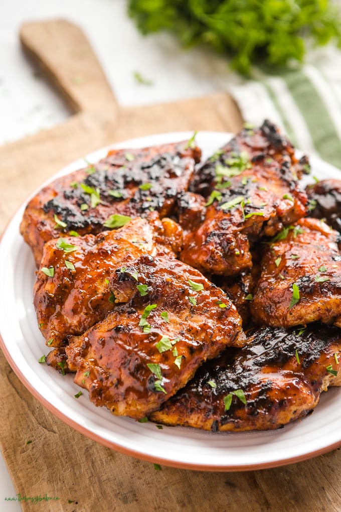 bbq chicken stacked on a white plate