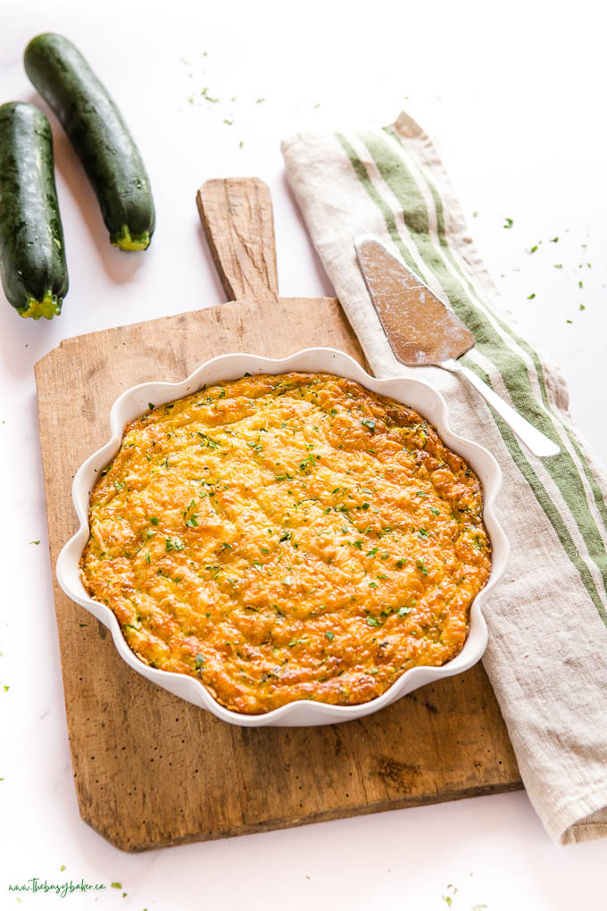 zucchini pie in white pie plate with the pie lifter beside