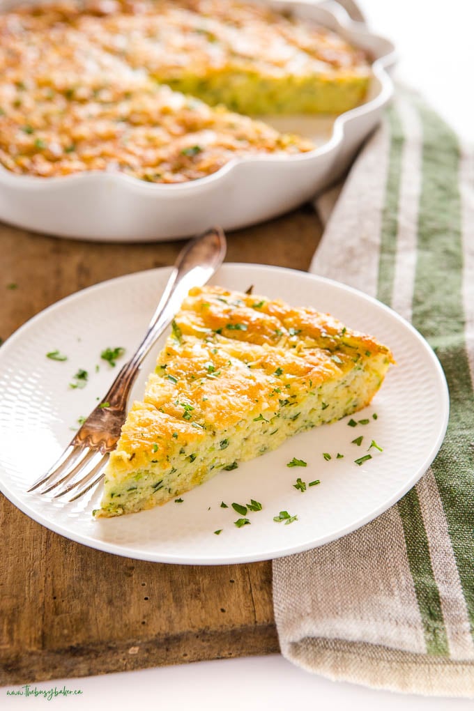 close up of zucchini slice on white plate with fork laying beside