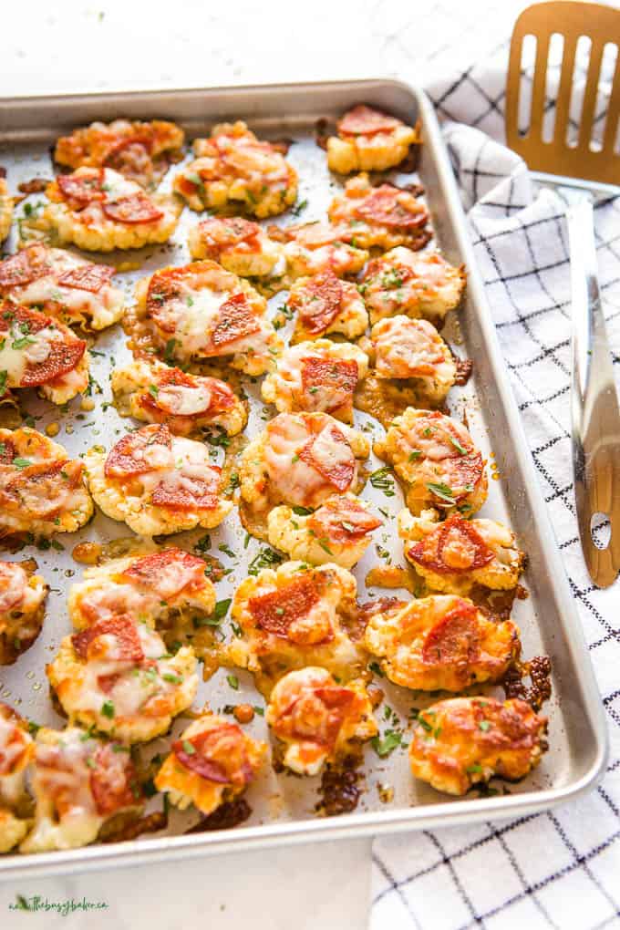 roasted cauliflower with pizza toppings on a sheet pan
