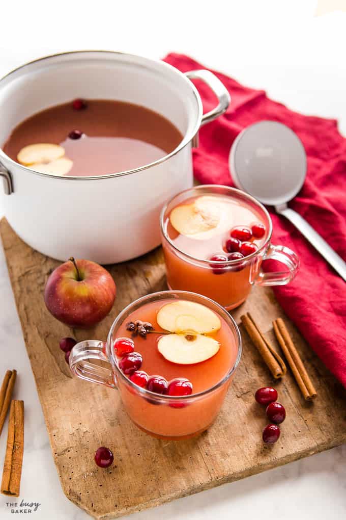 kinderpunsch in glass mug with apple slice and cranberries