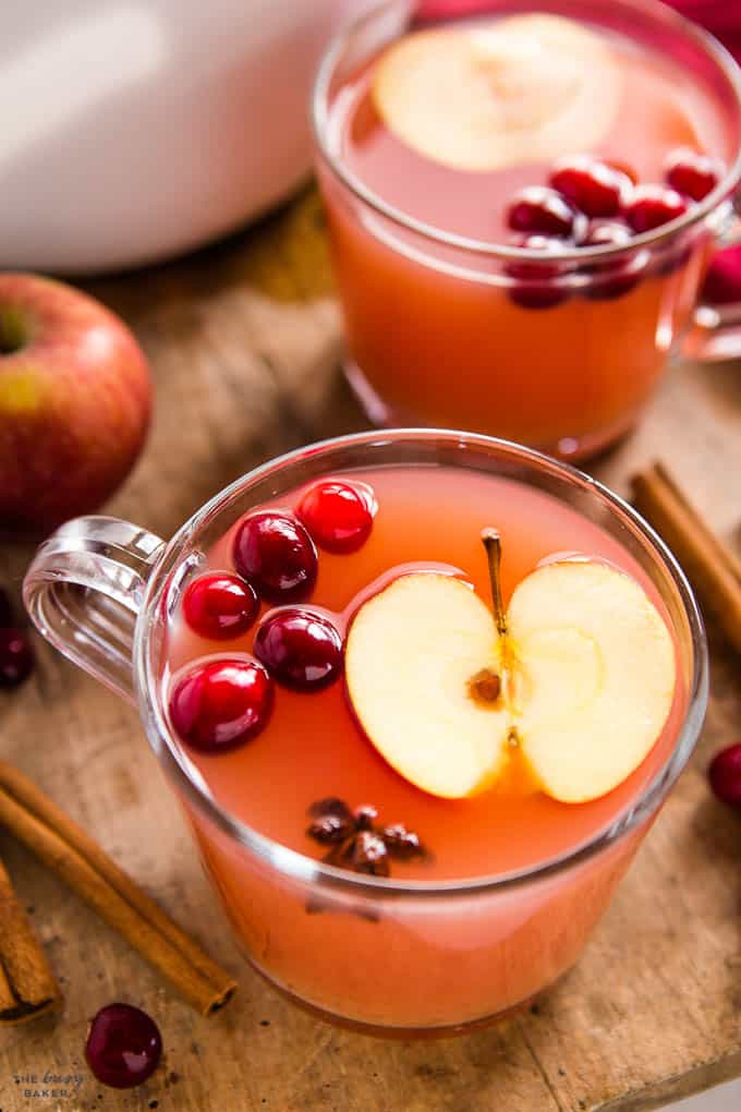 apple slice and cranberries in glass mug of kinderpunsch