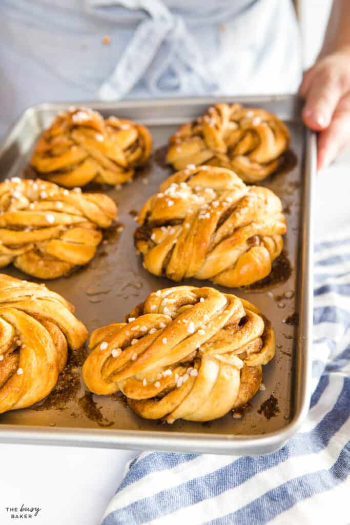 hands holding baking tray of Swedish cinnamon buns