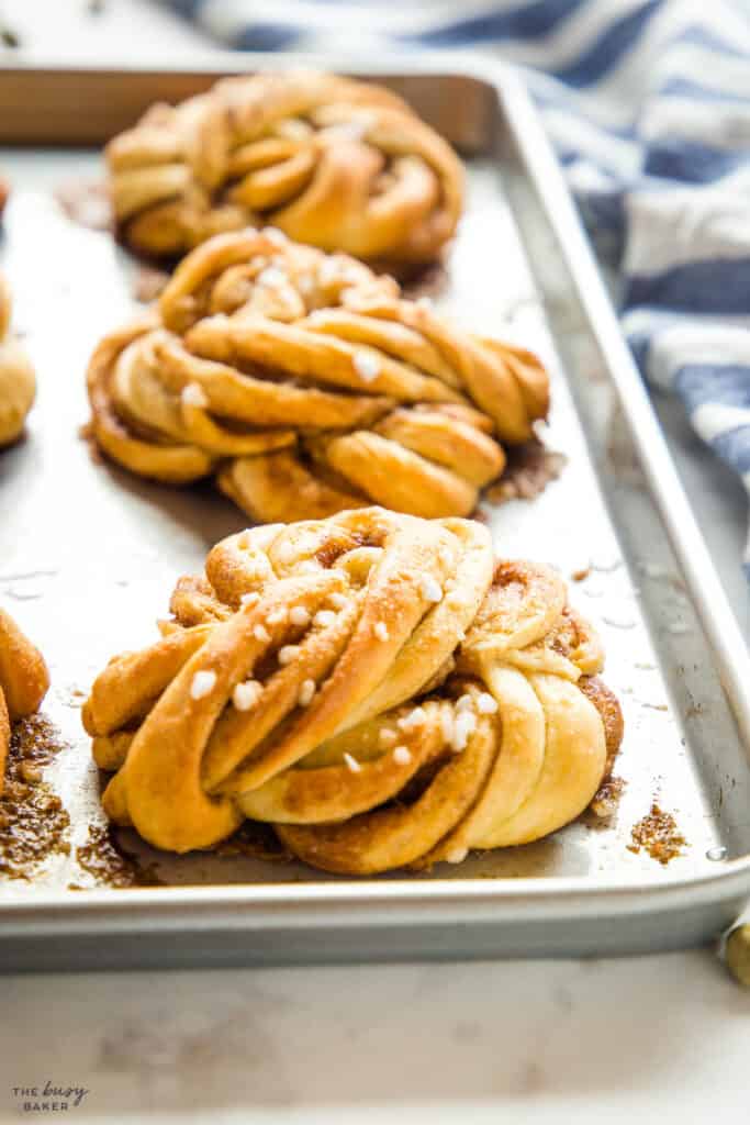 kanelbullar on baking sheet with pearl sugar