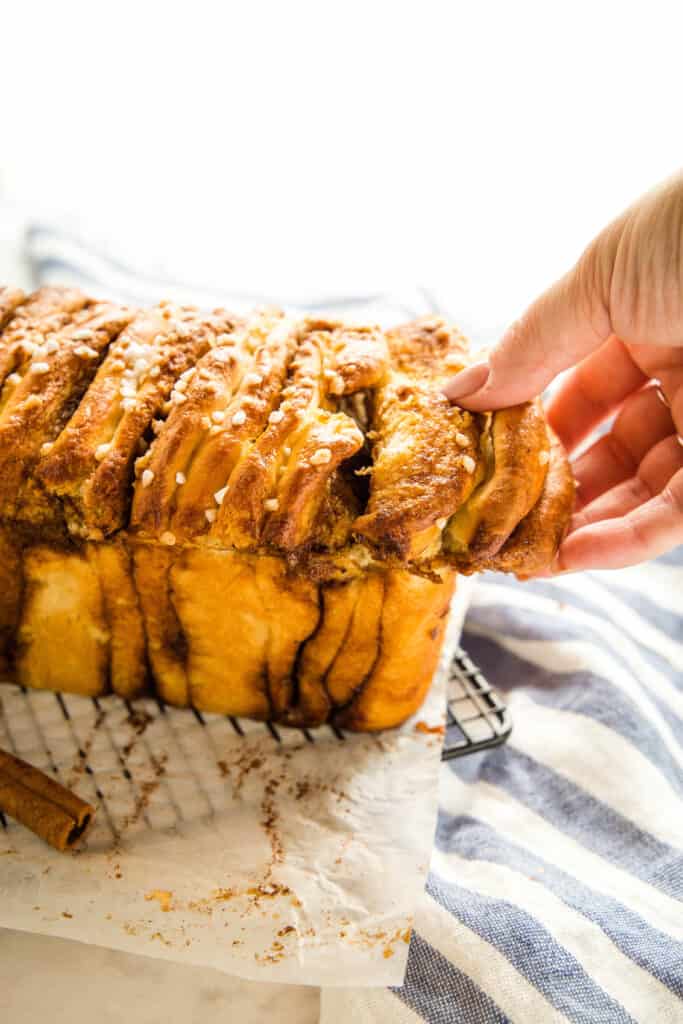 hand reaching for pull apart bread with cinnamon sugar