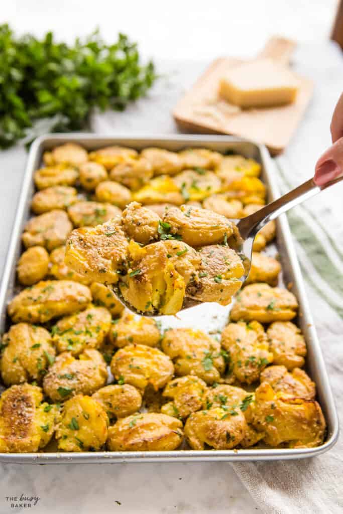 hand serving smashed potatoes