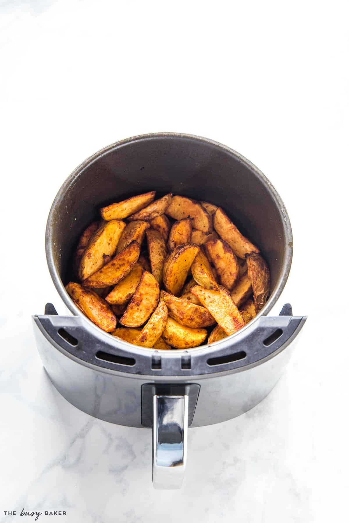 crispy potato wedges in the basket of the air fryer
