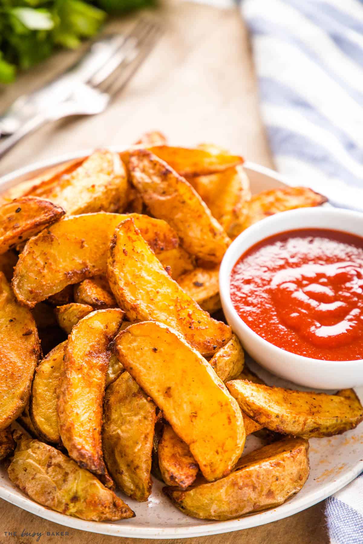 plate of crispy potato wedges with ketchup