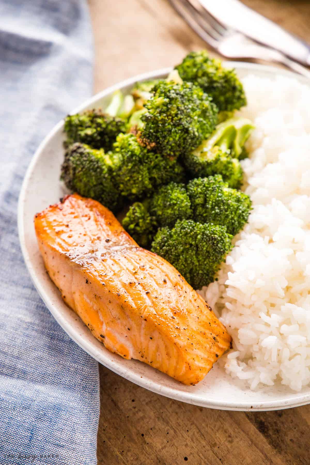 Baked Salmon cooked in the air fryer on plate with rice and broccoli