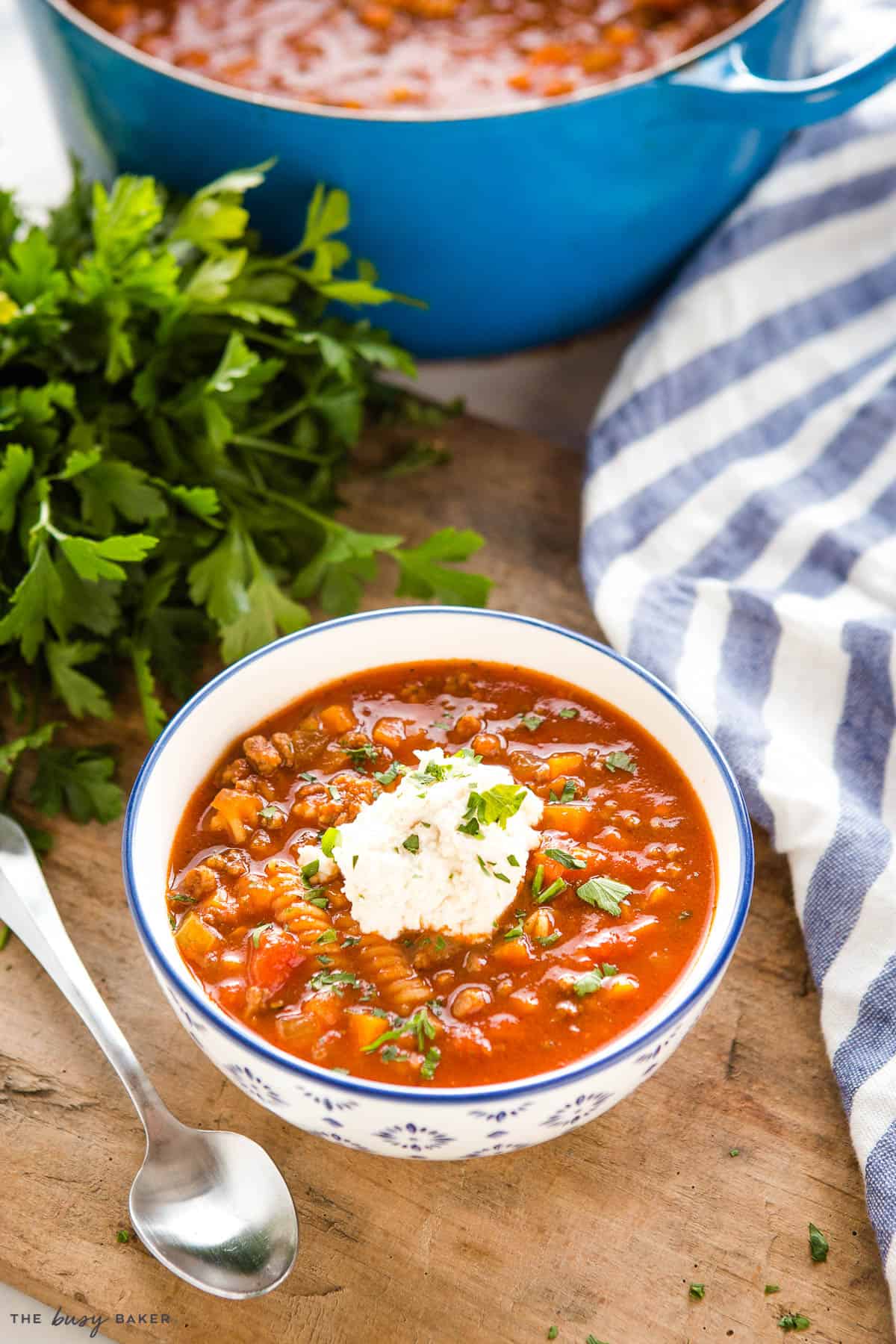 Italian tomato soup with pasta , cheese and parsley on top