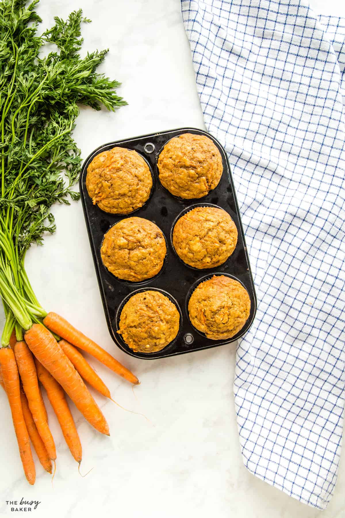 overhead image: muffins in muffin pan with fresh carrots