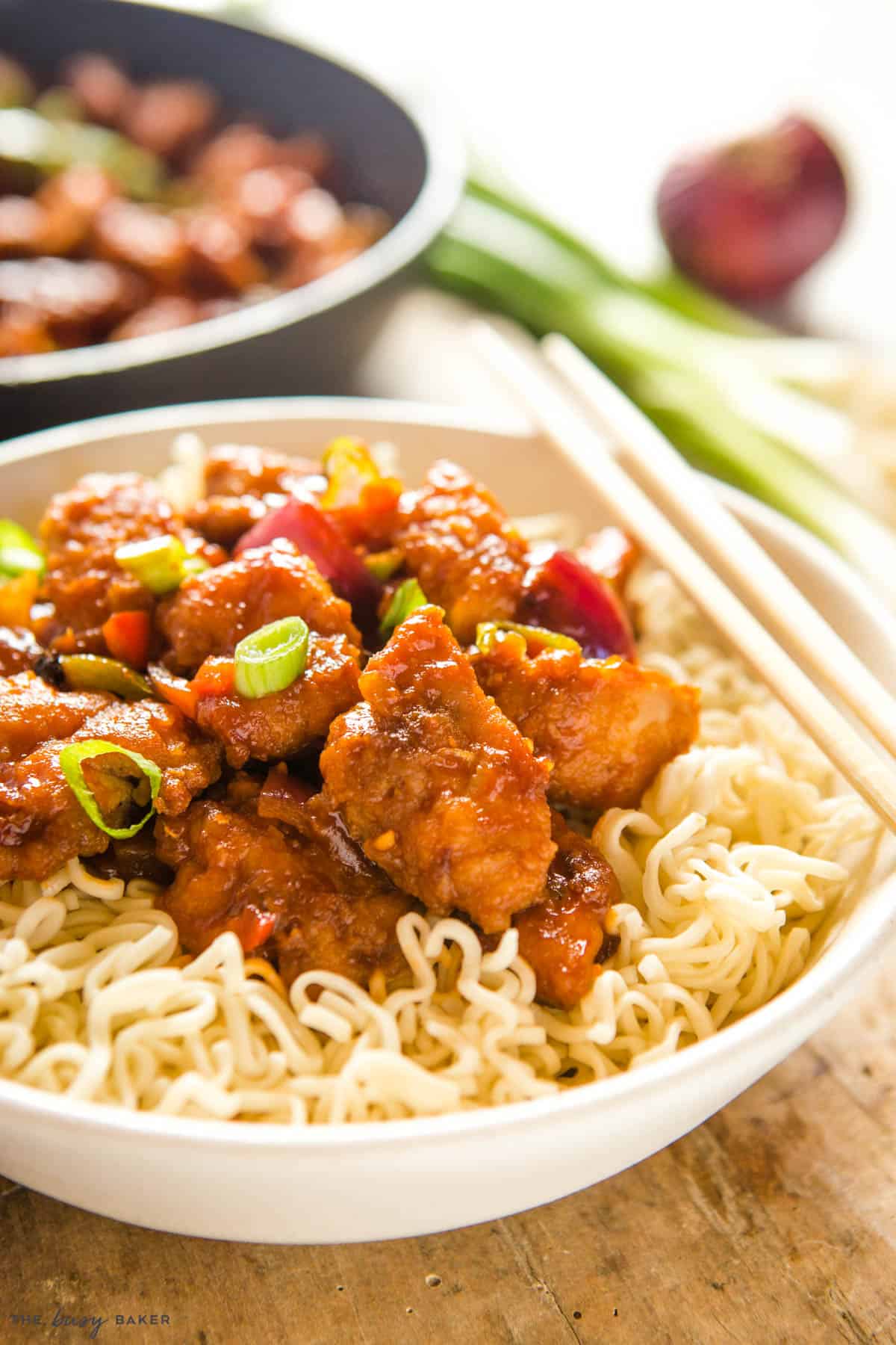 asian chicken over noodles with green onions and red chilis