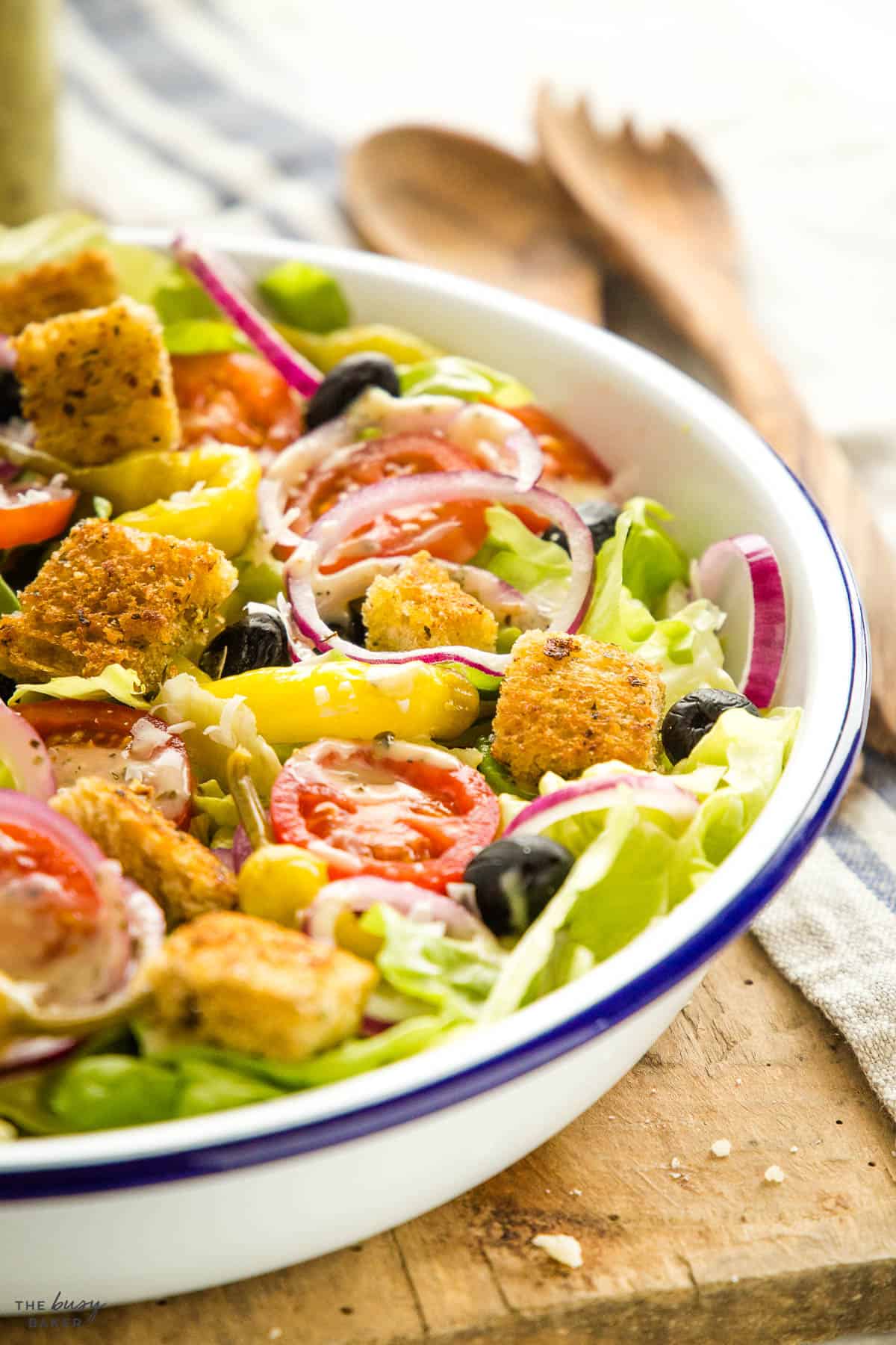 closeup image:  salad recipe with croutons, onions, olives and tomatoes