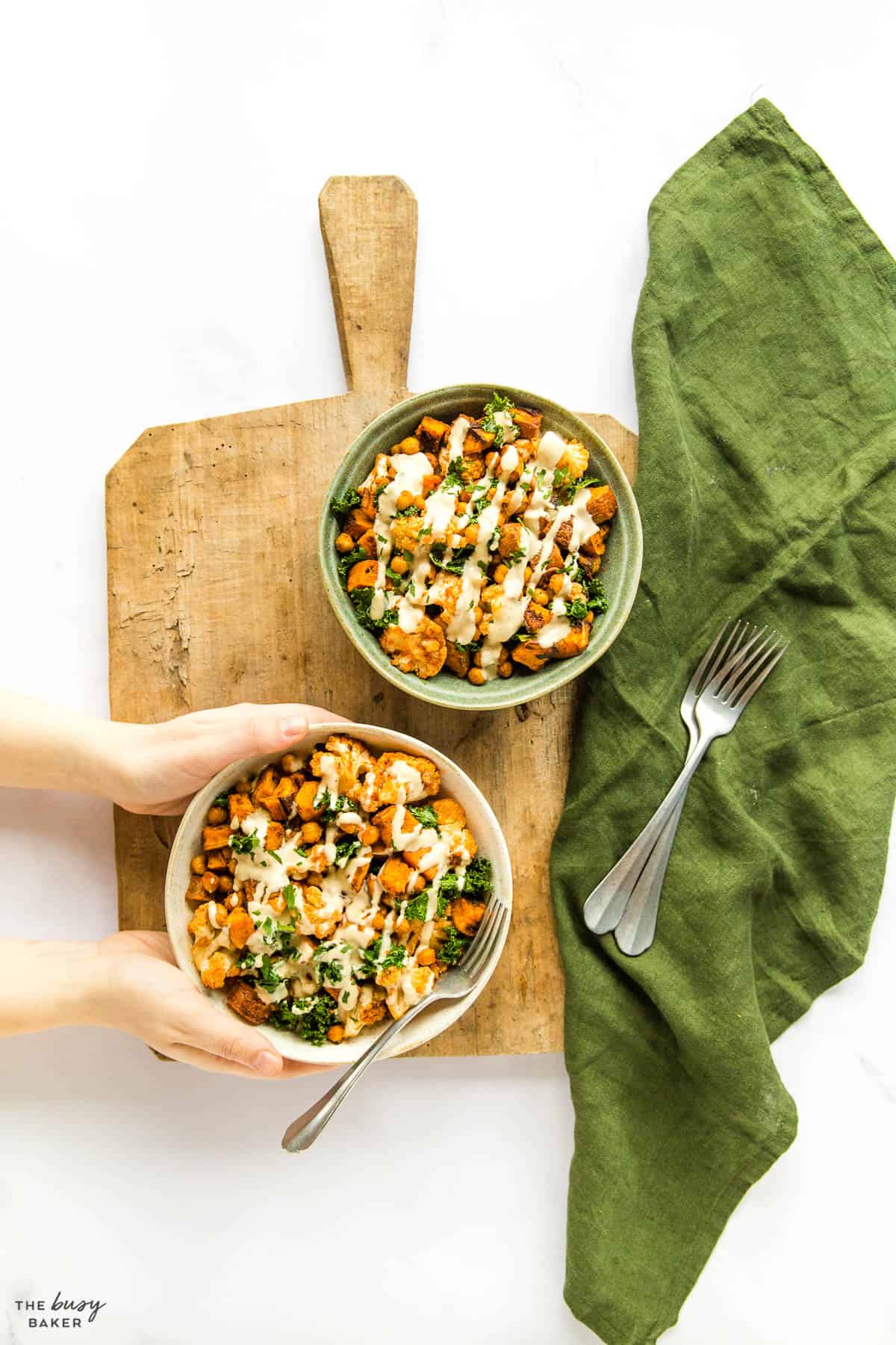 overhead image: two healthy bowls with veggies and tahini sauce