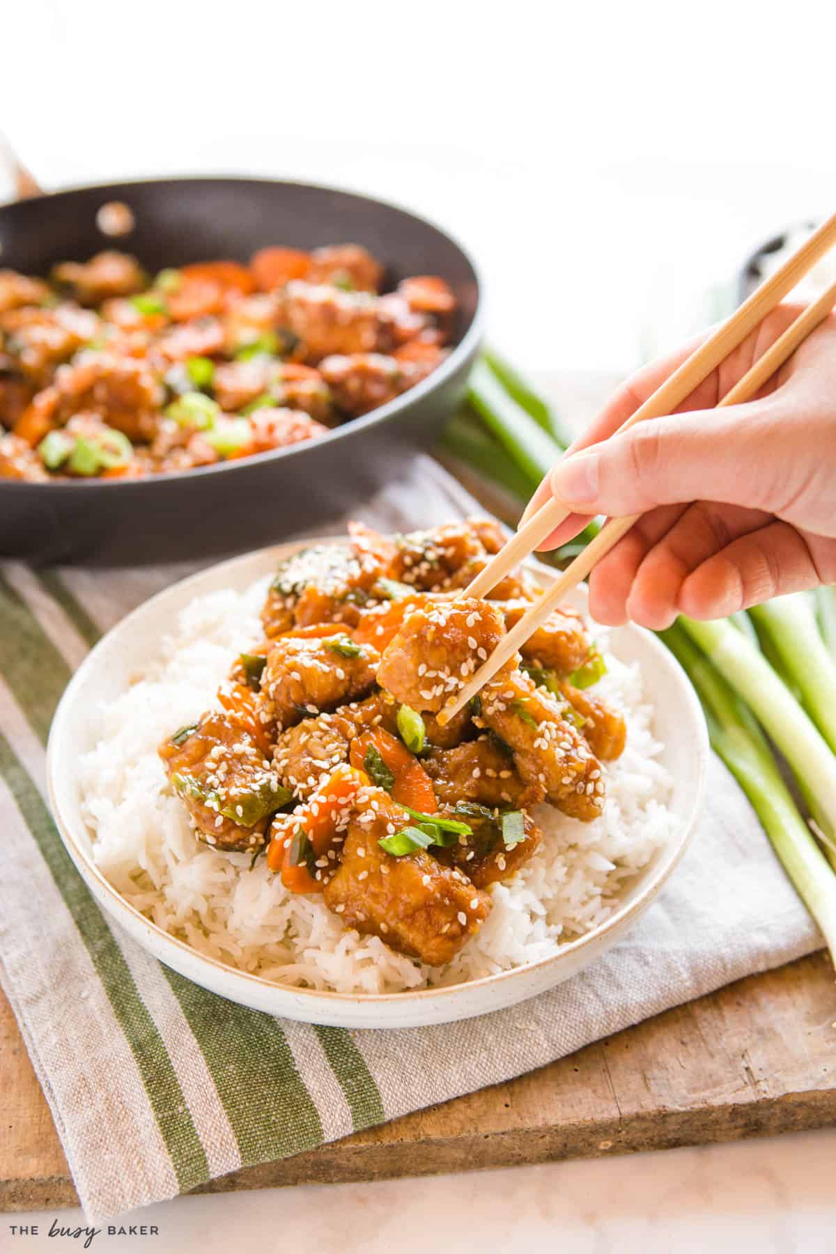 hand holding chopsticks with Chinese takeout recipe