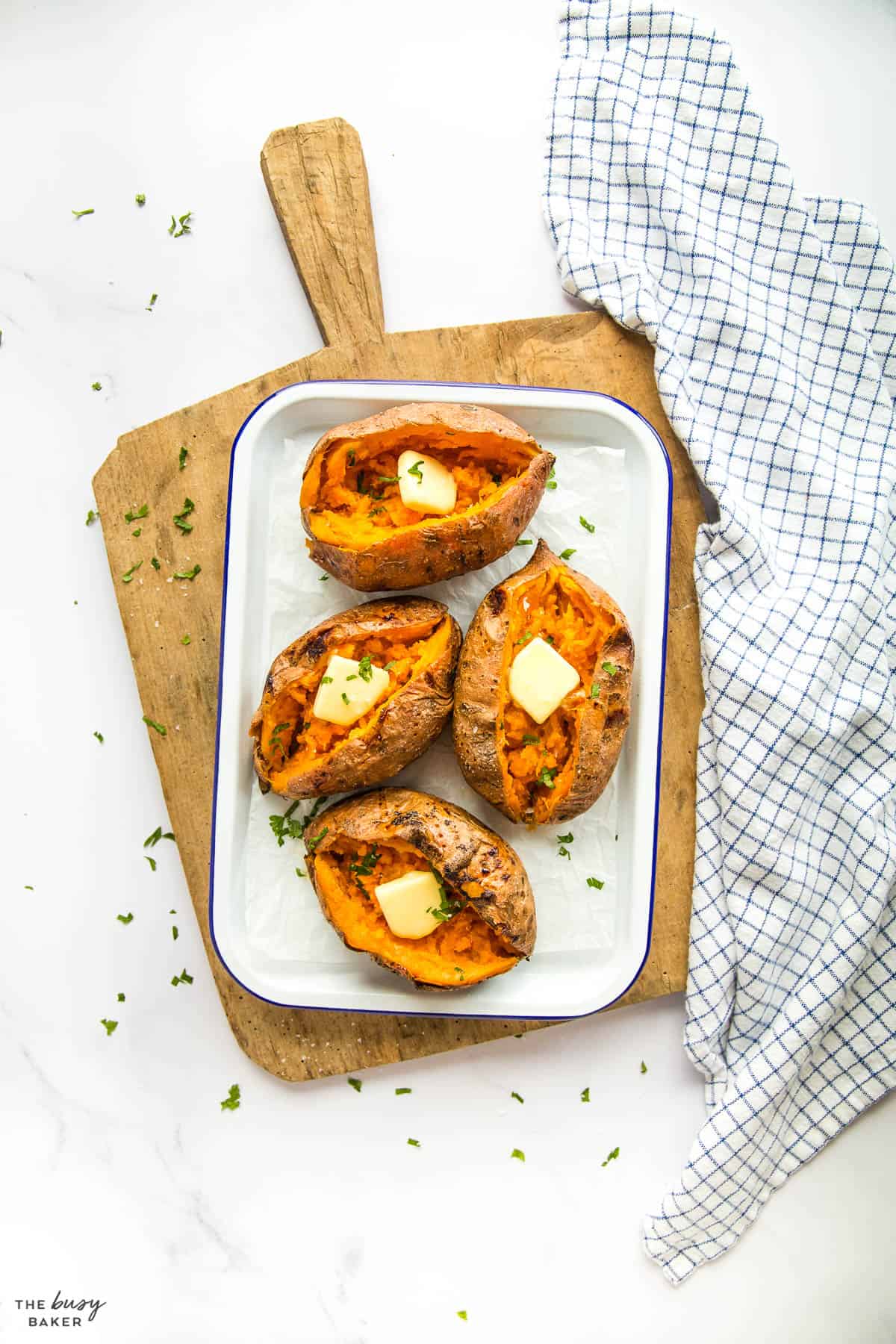 overhead image: 4 air fryer baked sweet potatoes with butter 