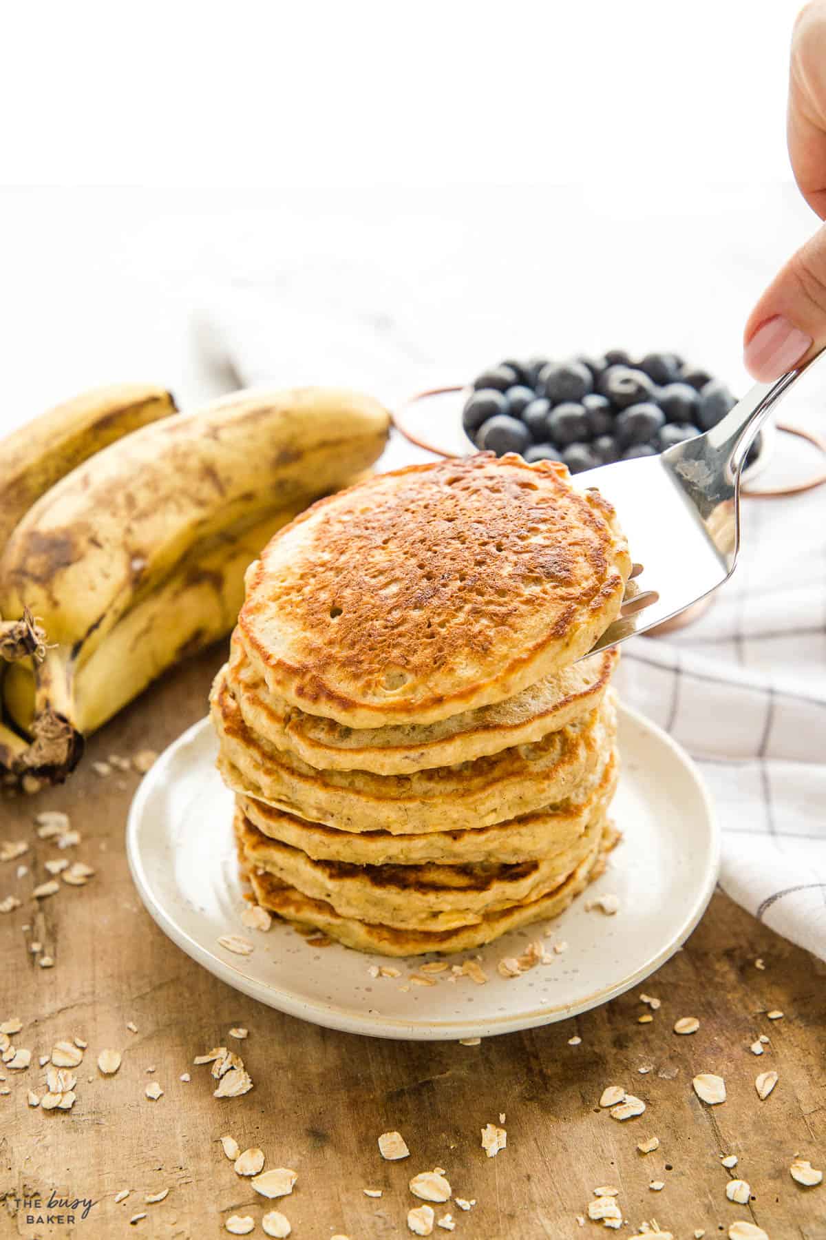 hand serving banana oatmeal pancakes