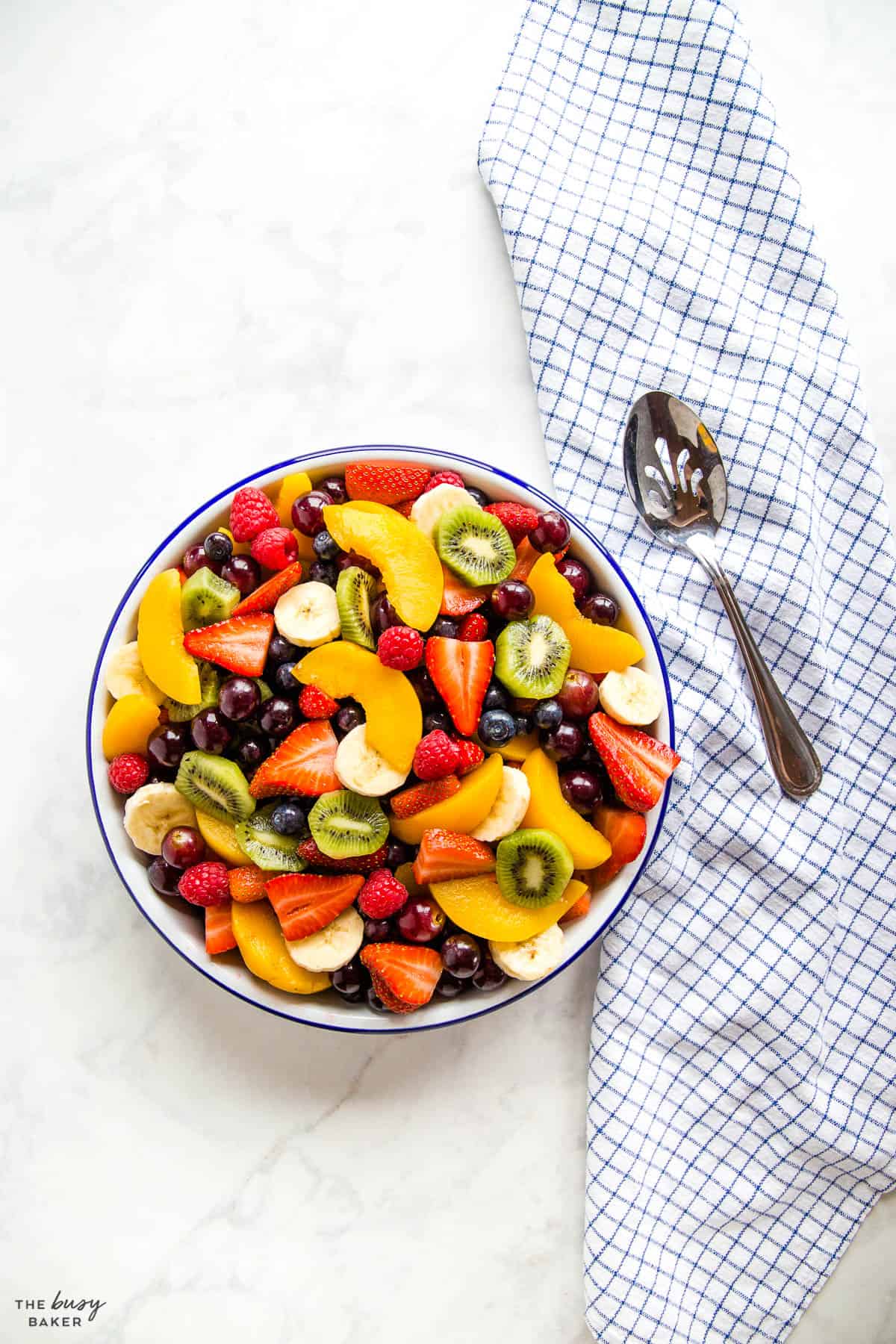 overhead image: mixed fruit in a white bowl with a blue rim