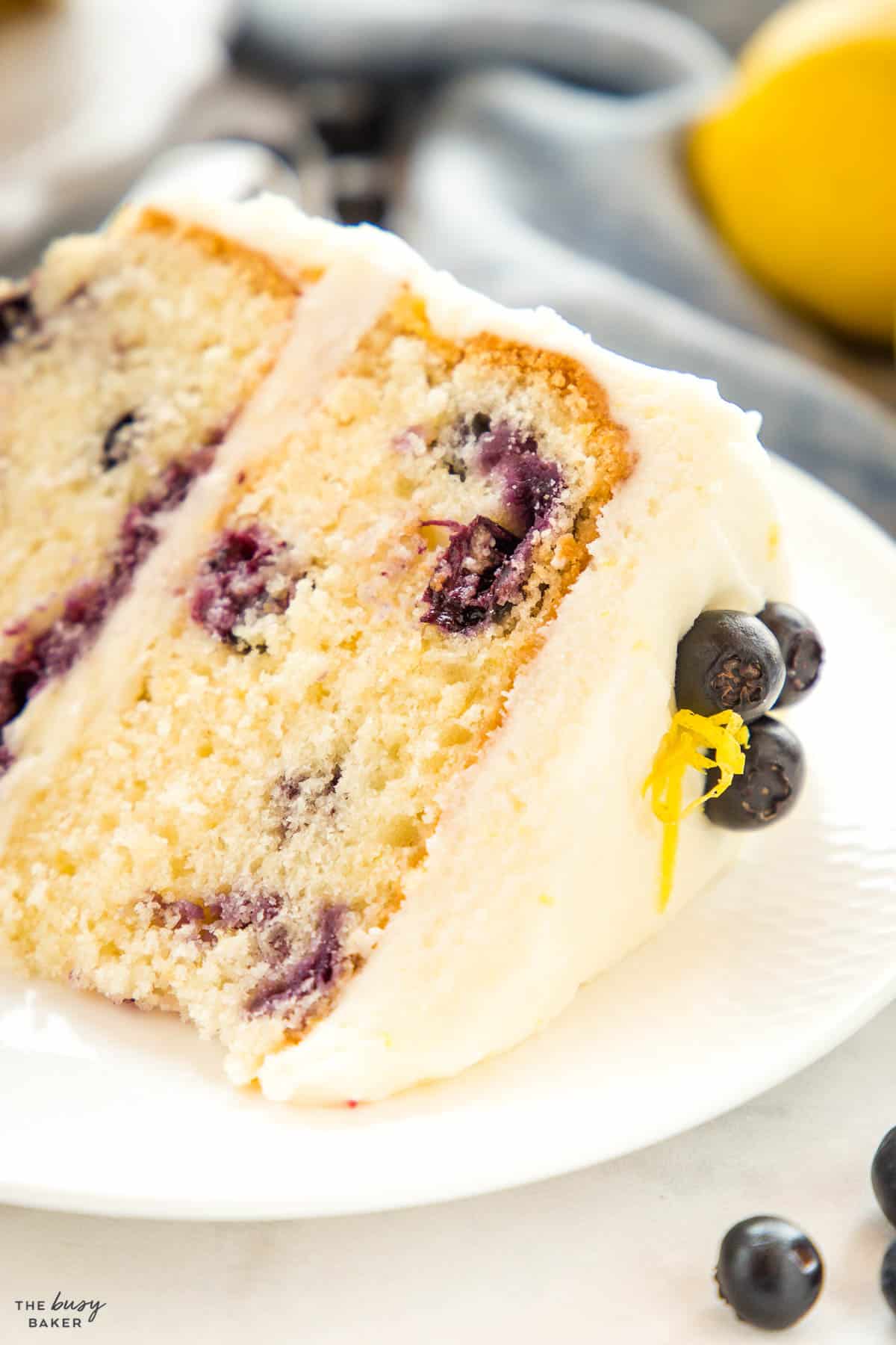 closeup image: tender lemon blueberry cake with lemon frosting