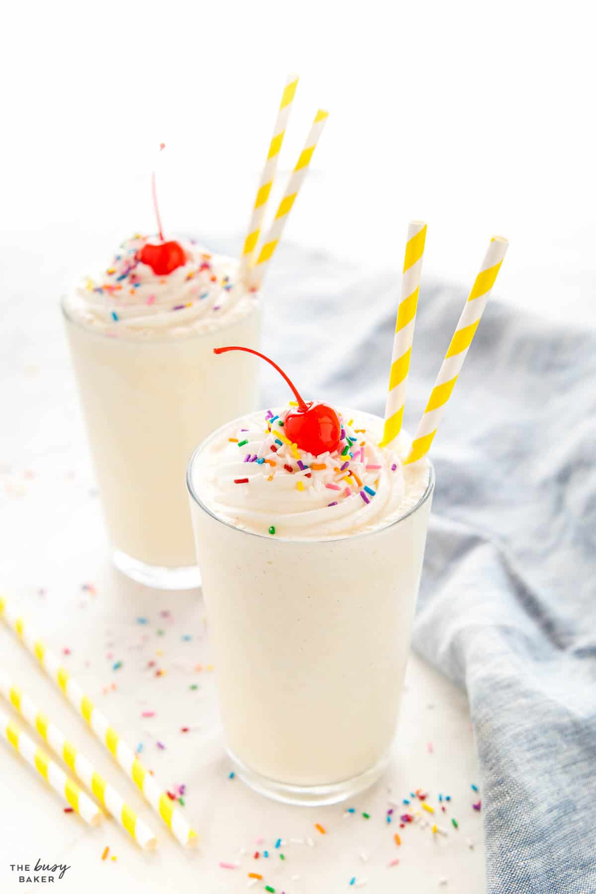 2 vanilla milkshakes with sprinkles and paper straws