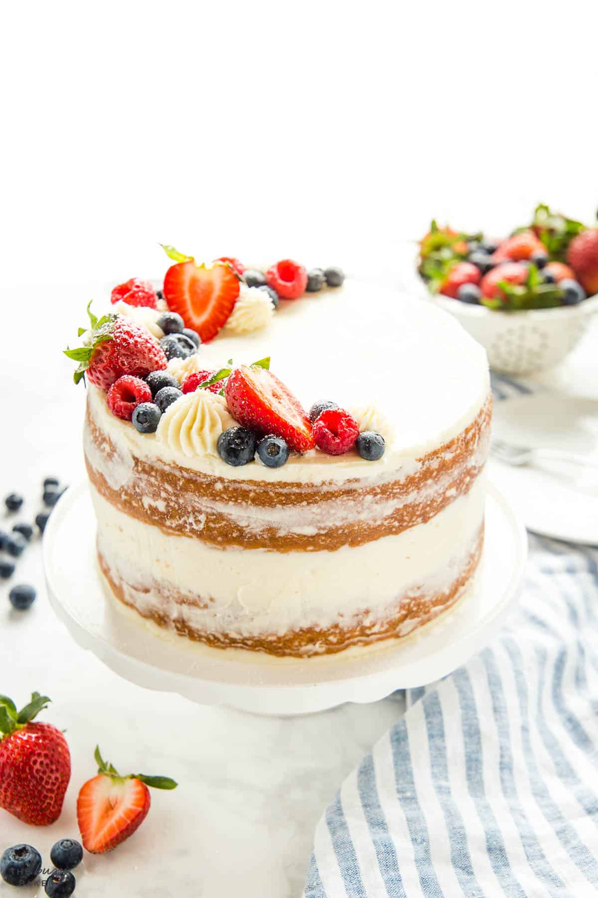 naked cake with fresh berries and white frosting 