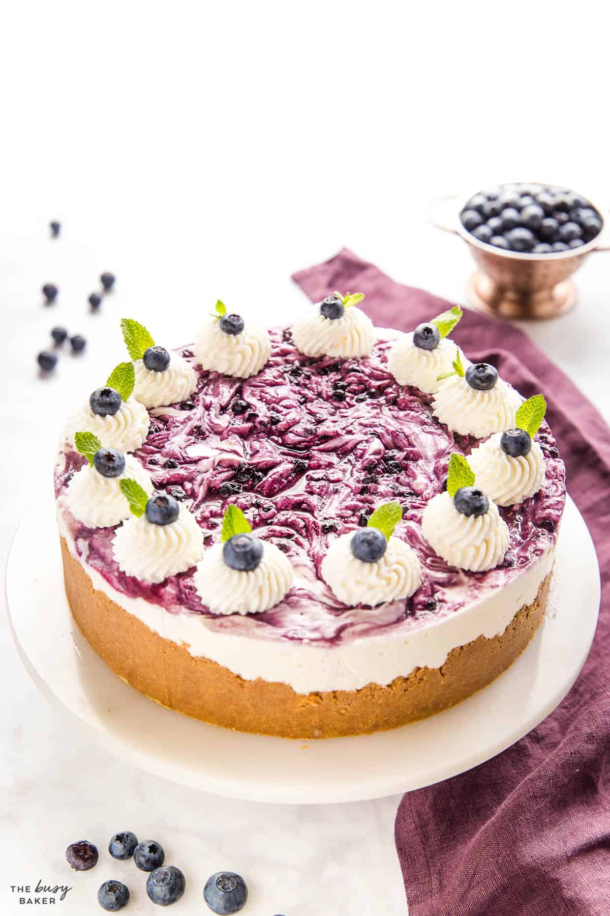 no bake blueberry cheesecake on a cake stand