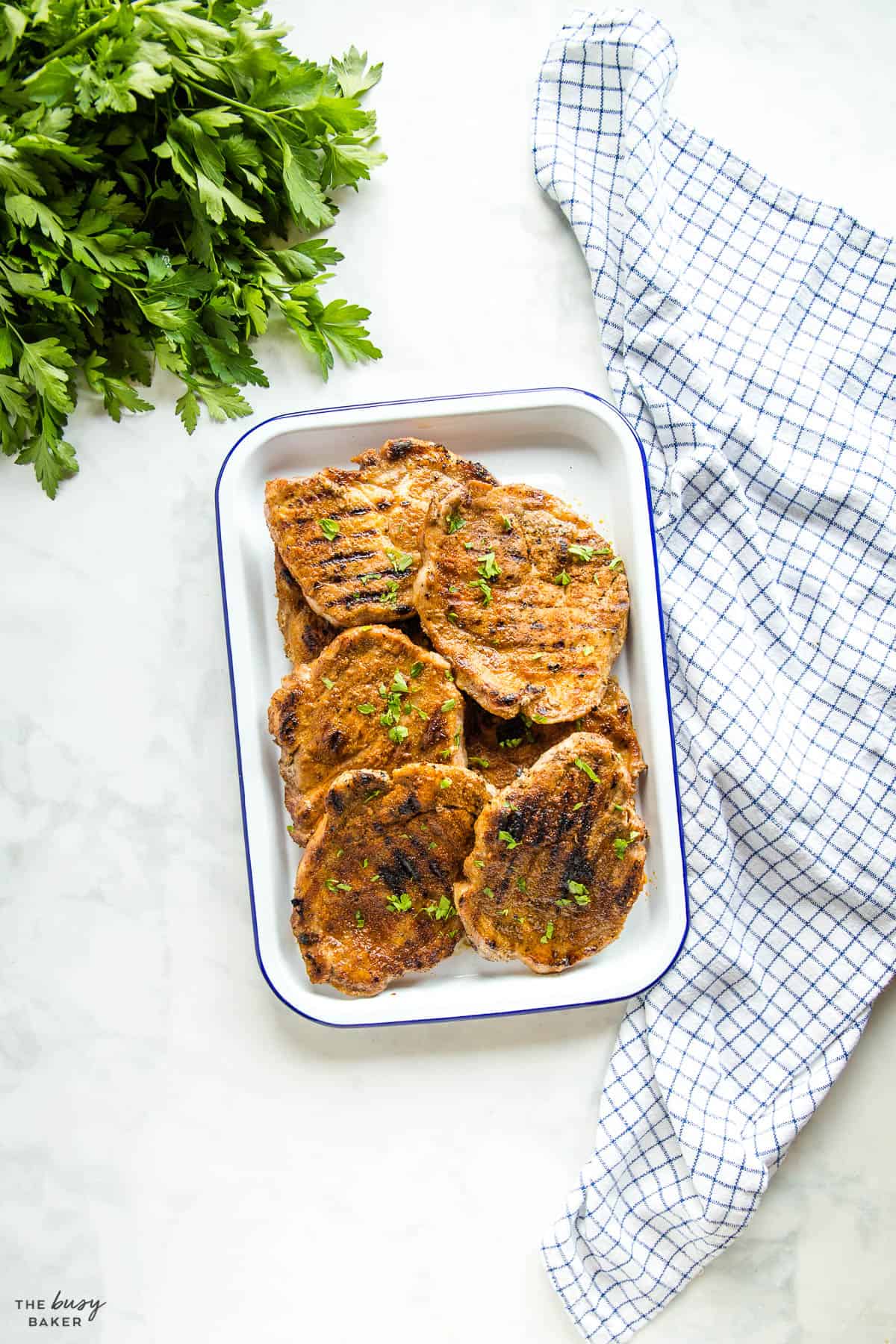 grilled pork shoulder steaks on a white tray