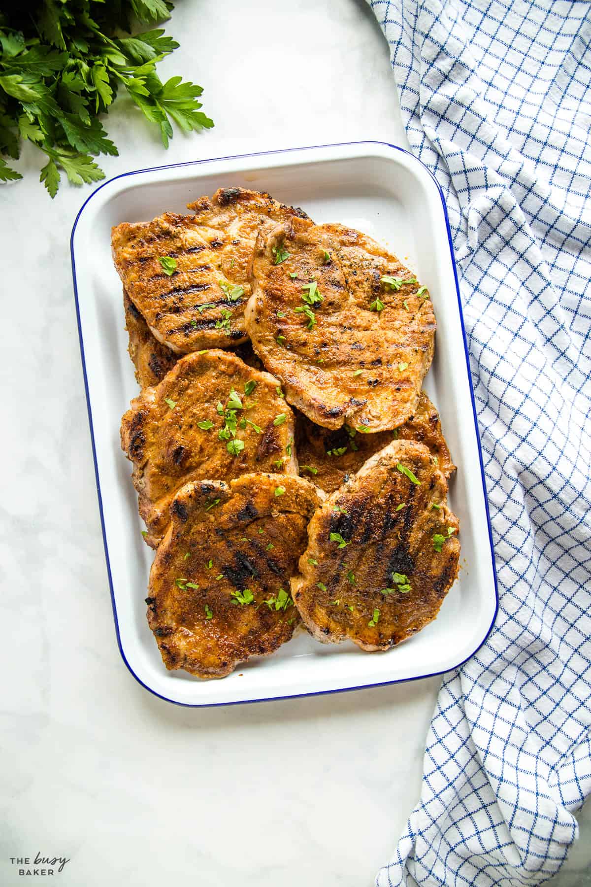 grilled pork steaks (boston butt) on white platter with blue rim