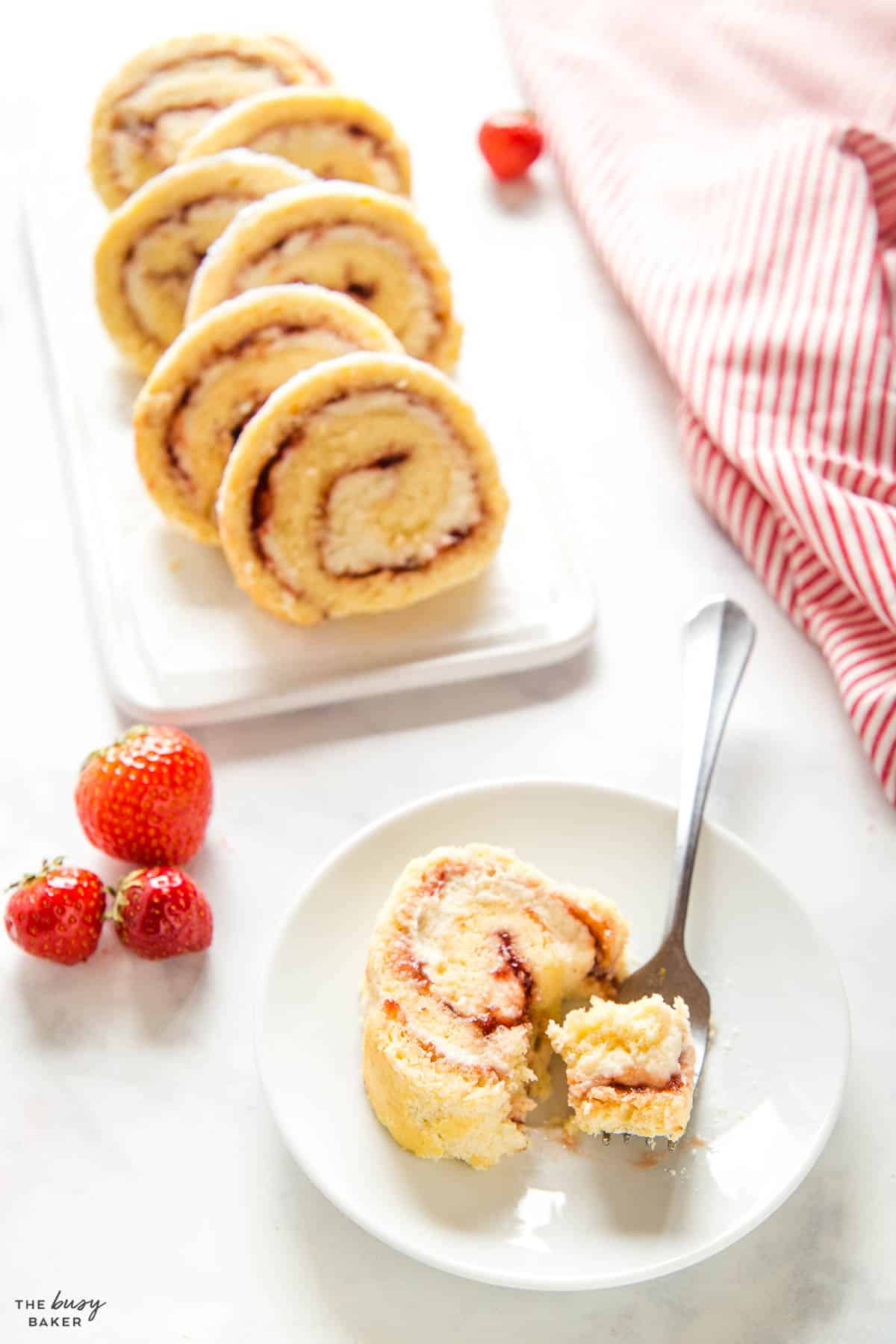 rolled vanilla dessert slice with cream and strawberry jam