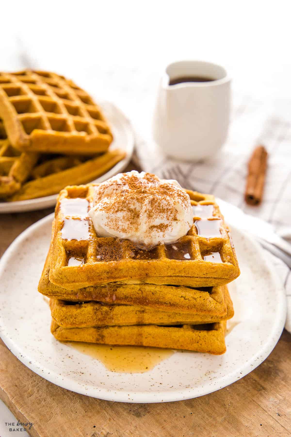stack of pumpkin waffles with maple syrup