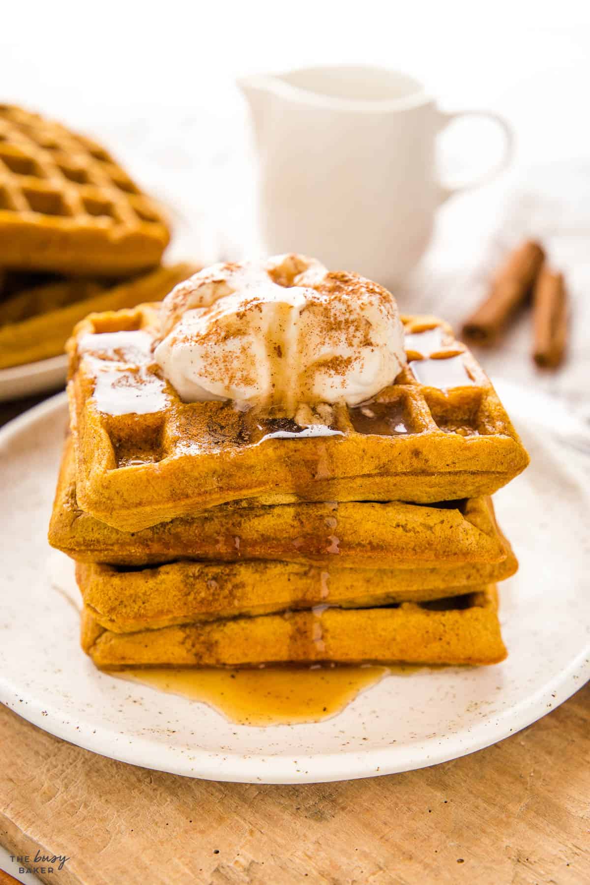 pumpkin waffles with whipped cream and maple syrup