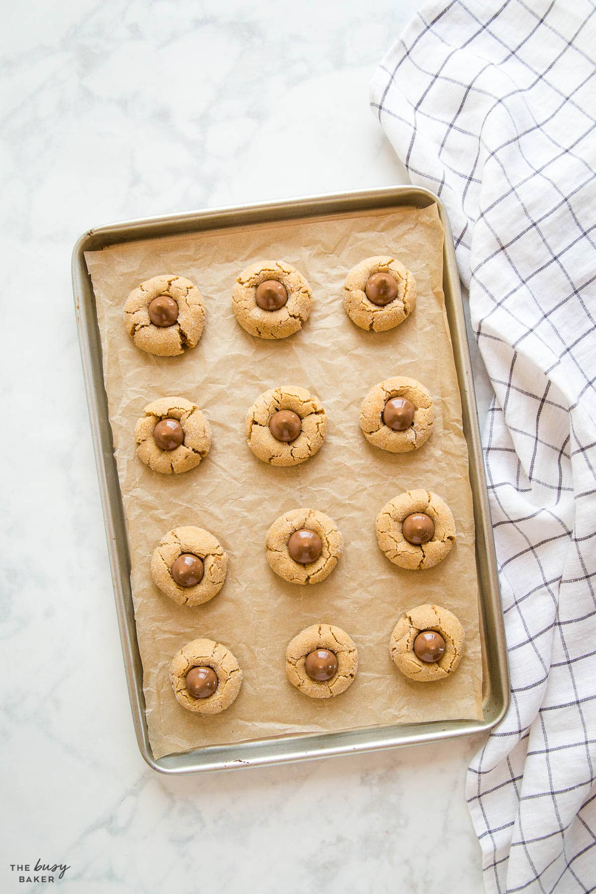 overhead image: peanut butter blossoms on a baking sheet lined with parchment paper