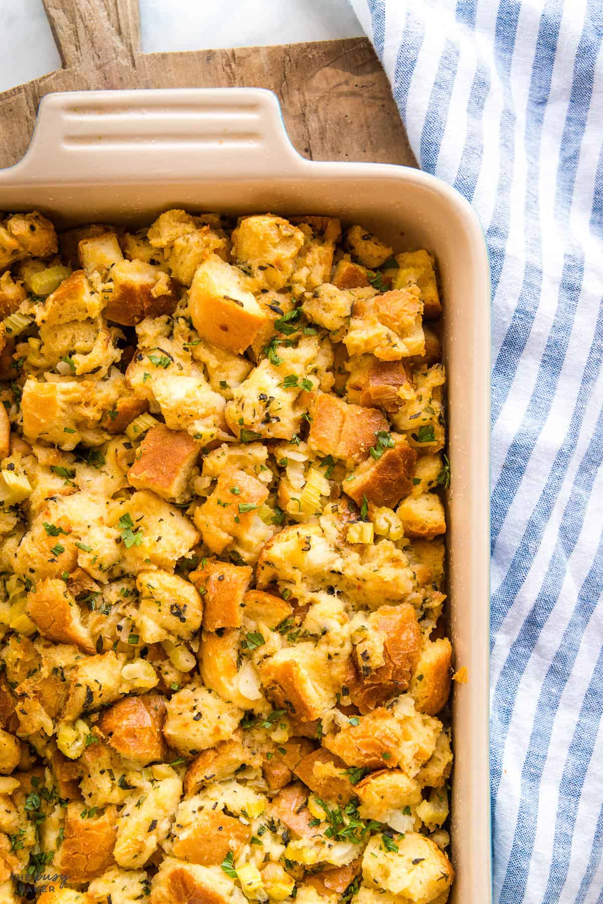 holiday stuffing in a baking pan with fresh herbs