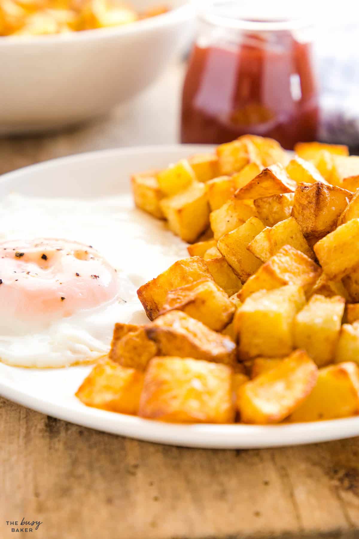 crispy breakfast potatoes on a plate with a fried egg