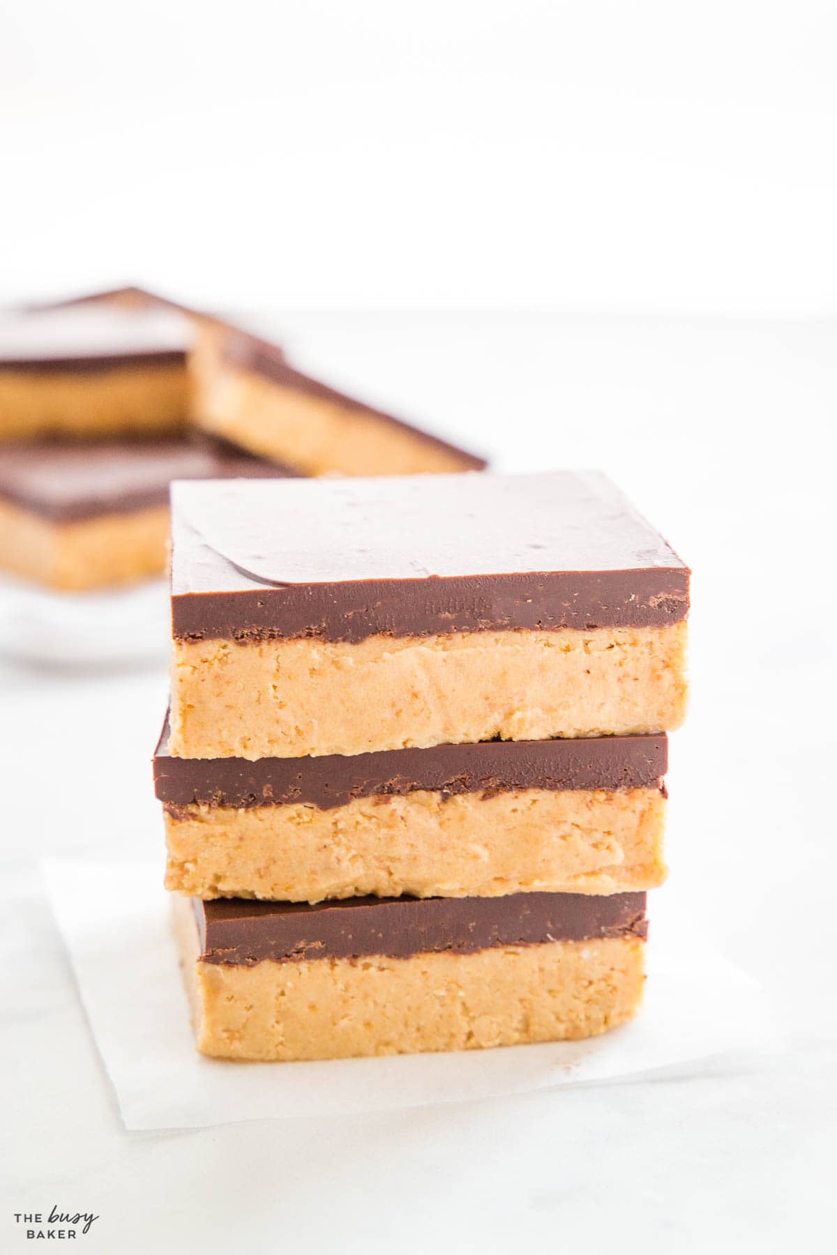 stack of peanut butter bars with thick chocolate layer