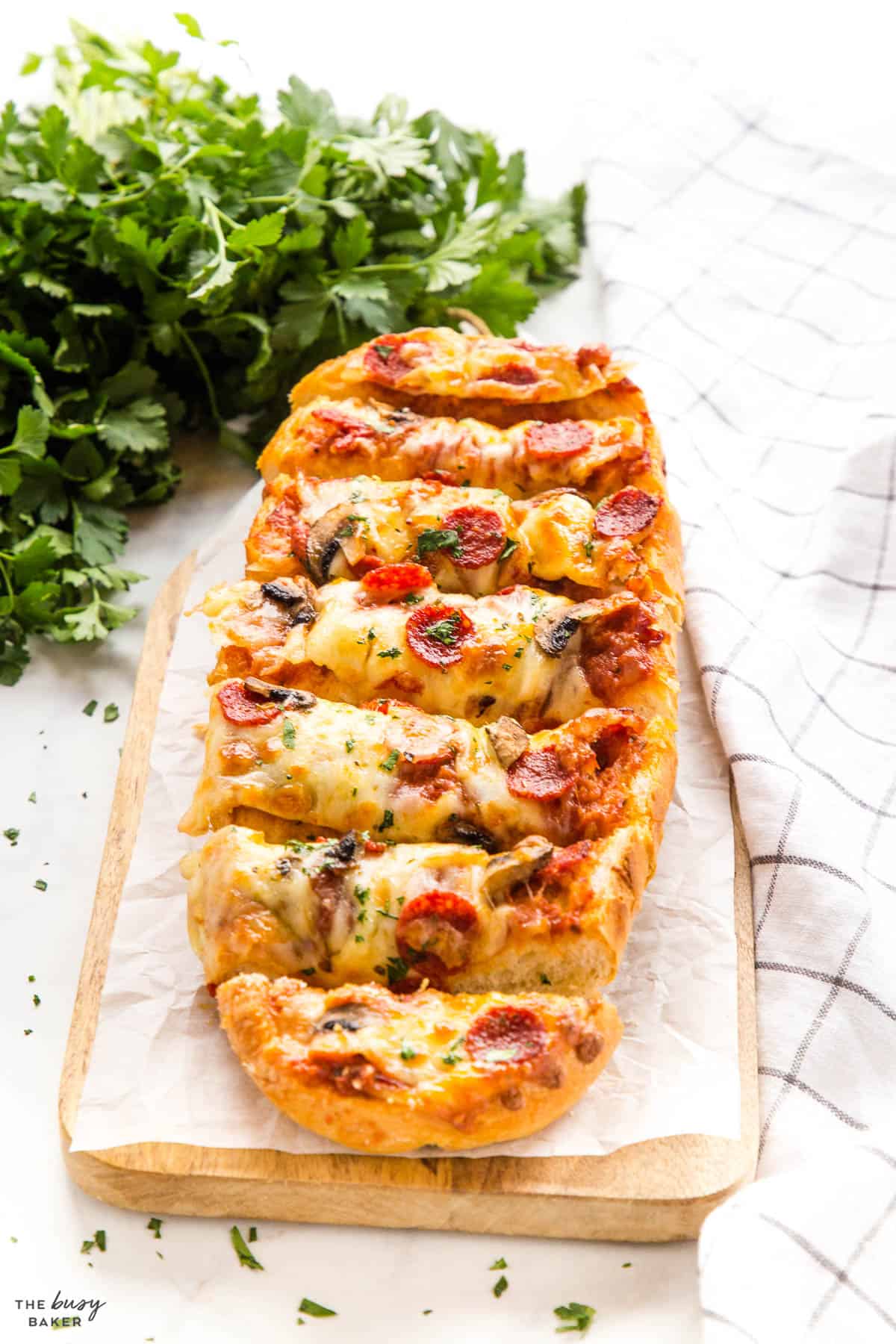french bread pizza sliced with pepperoni and mushrooms